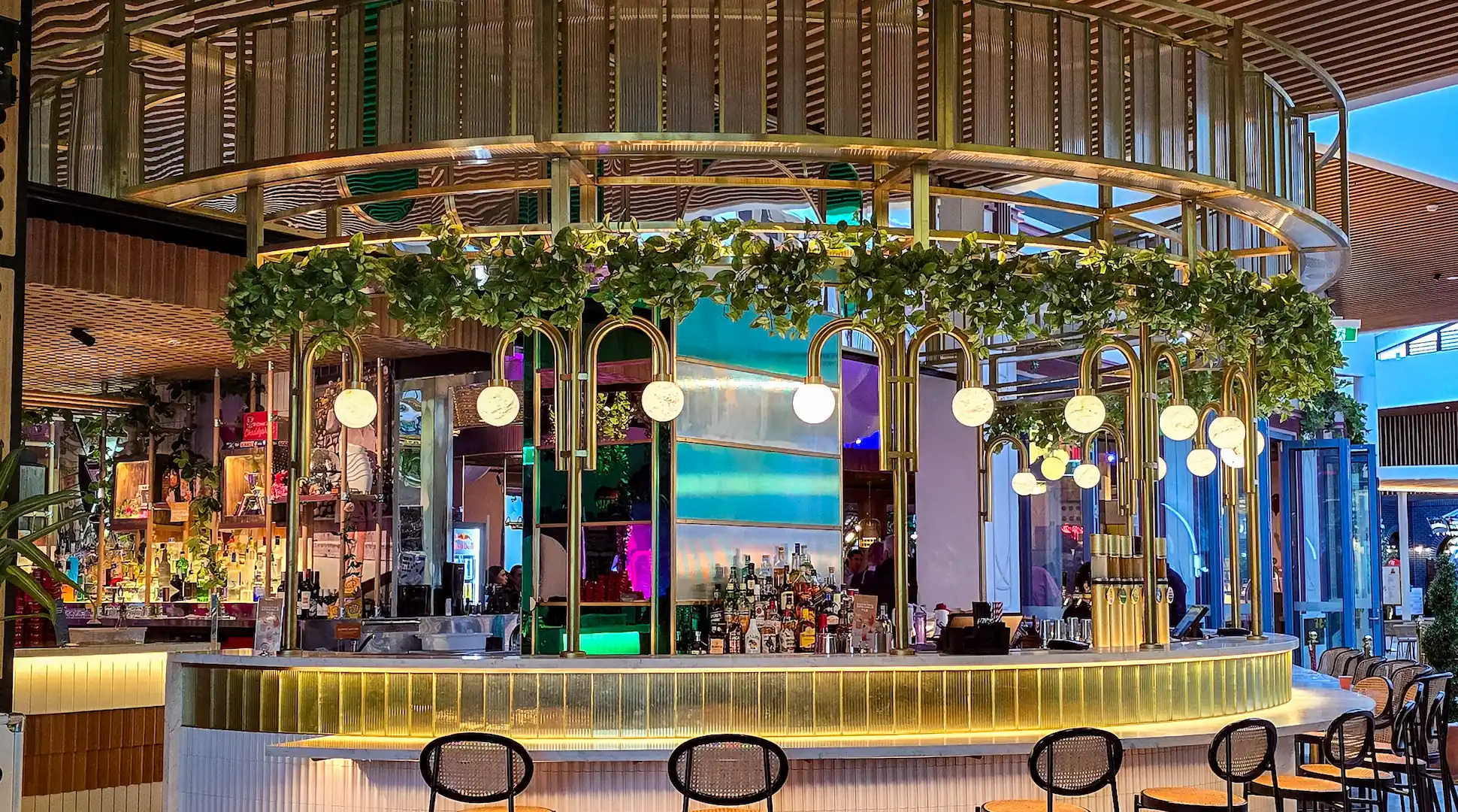 Stunning gold architectural interior filigree, adorning a semicircle shaped bar at Archie Brothers