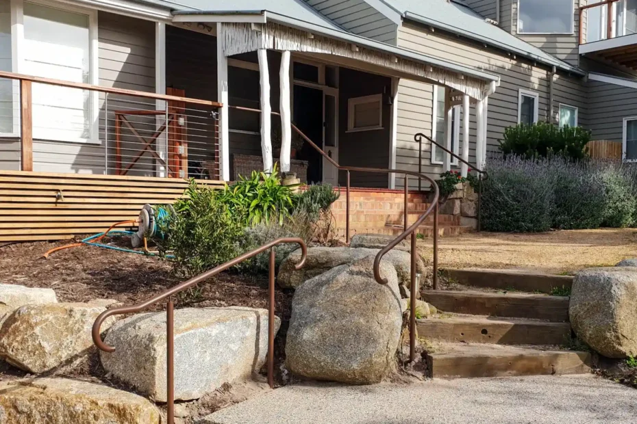 Brown metal hand railing adorning steps to a modern suburban home, front entrance